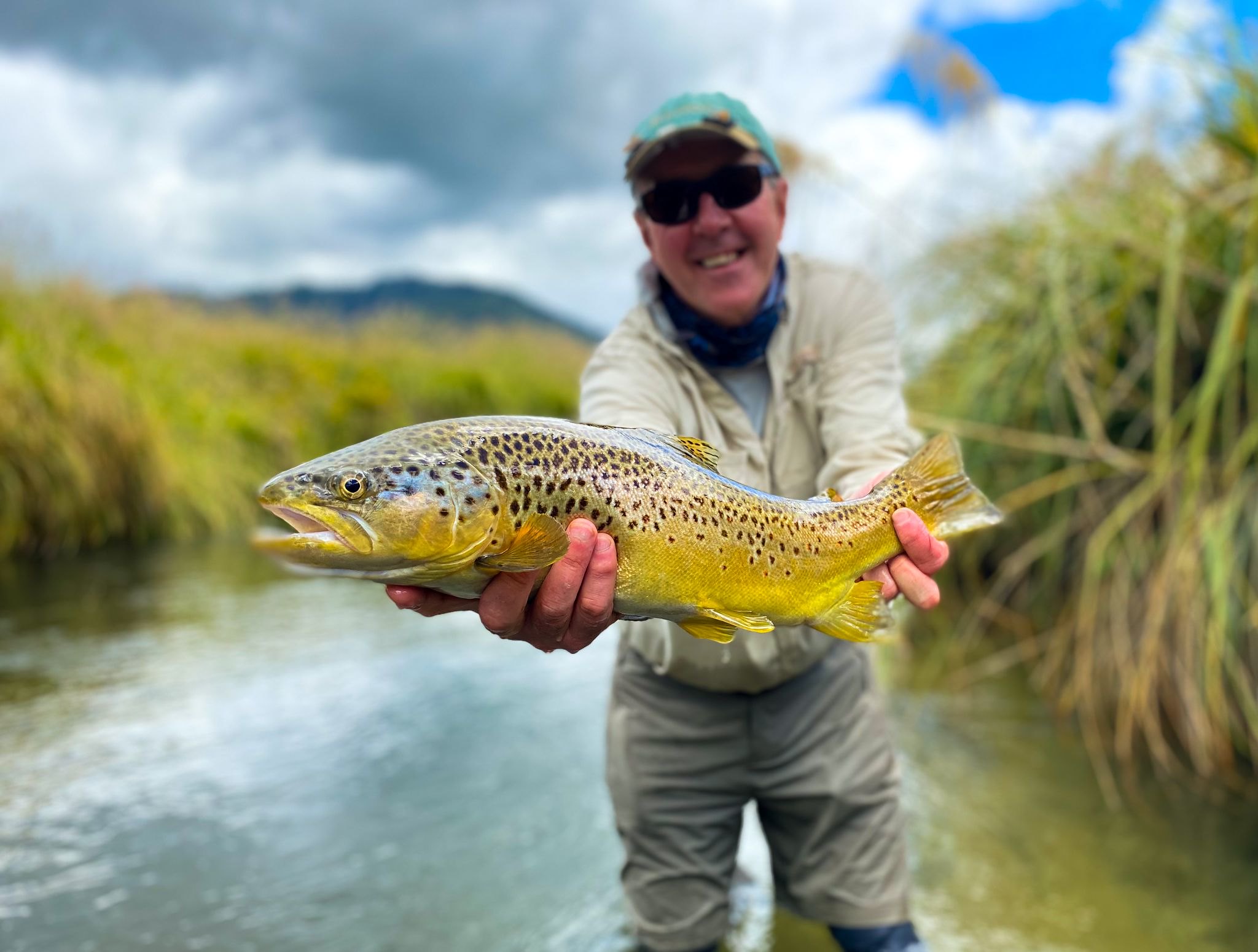 old man holding freshly fished trout