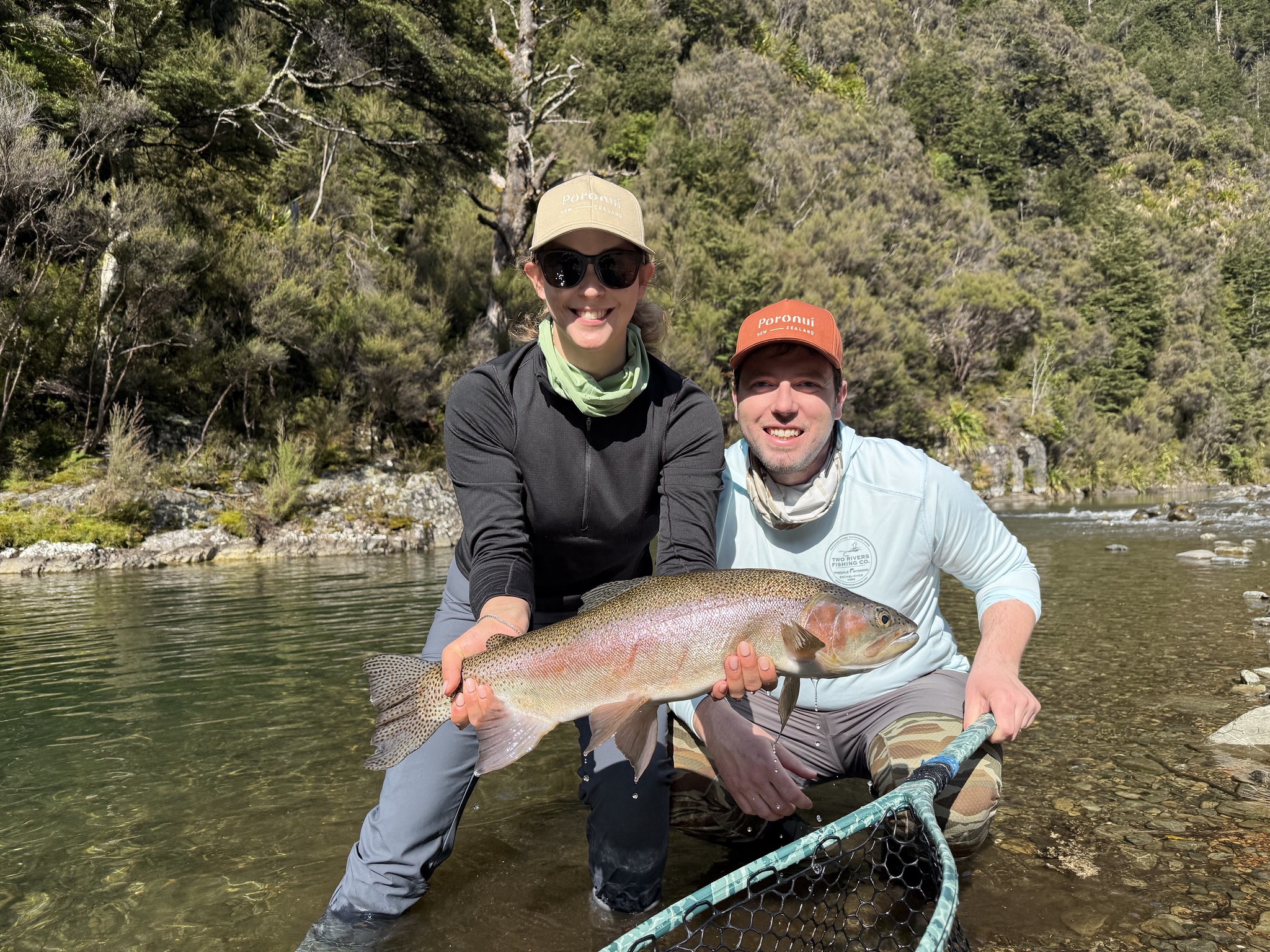 happy couple holding rainbow trout